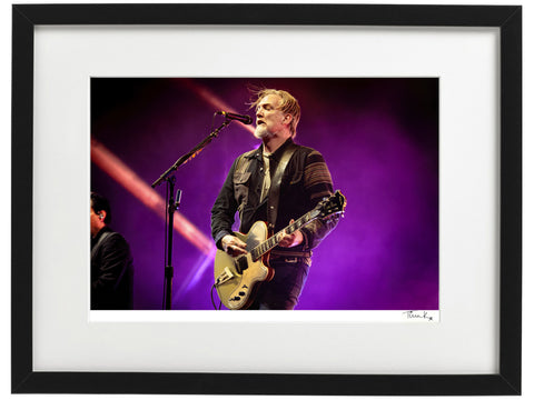 Josh Homme is singing and playing guitar onstage at Glastonbury Festival 2023 with Queens of the Stone Age. Framed photographic print by Tina K Photography
