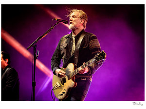 Josh Homme is singing and playing guitar onstage at Glastonbury Festival 2023 with Queens of the Stone Age. .Photographic print by Tina K Photography