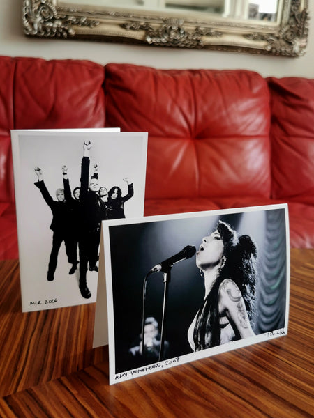 Two greeting cards on a table, My Chemical Romance (MCR) and Amy Winehouse on stage (by Tina K Photography)