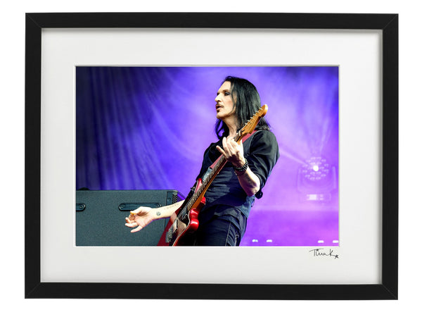 Framed Photo print of Brian Molko of Placebo playing red guitar on stage at the MK Stadium, 2022. Signed by Tina K Photography.