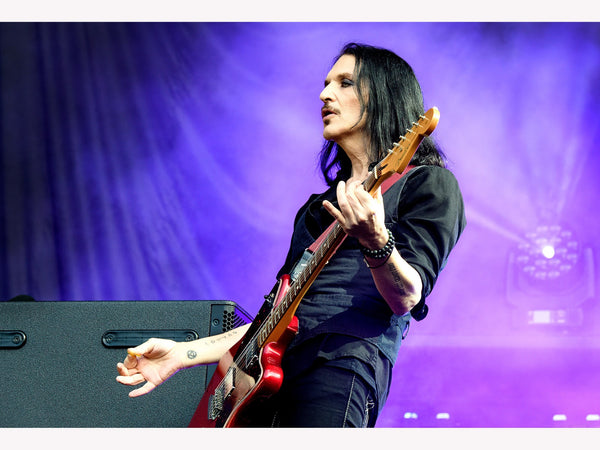 Photo print of Brian Molko of Placebo playing red guitar on stage at the MK Stadium, 2022. Signed by Tina K Photography.