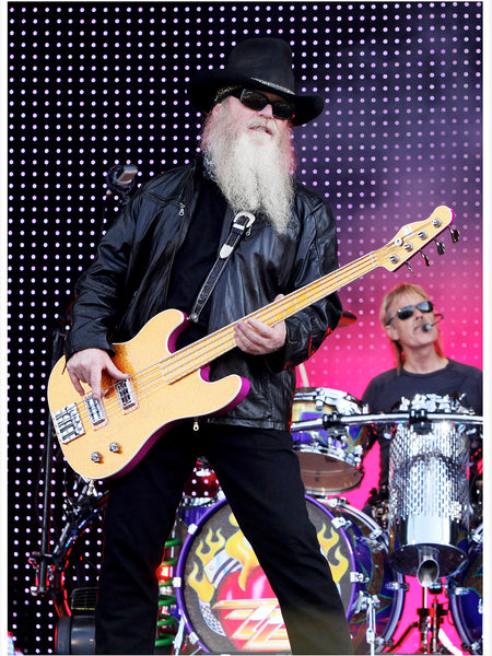 Dusty Hill of ZZ Top with bass guitar and black hat on stage at Download Festival 2009, Frank Beard drumming in background. Original print by Tina K Photography.